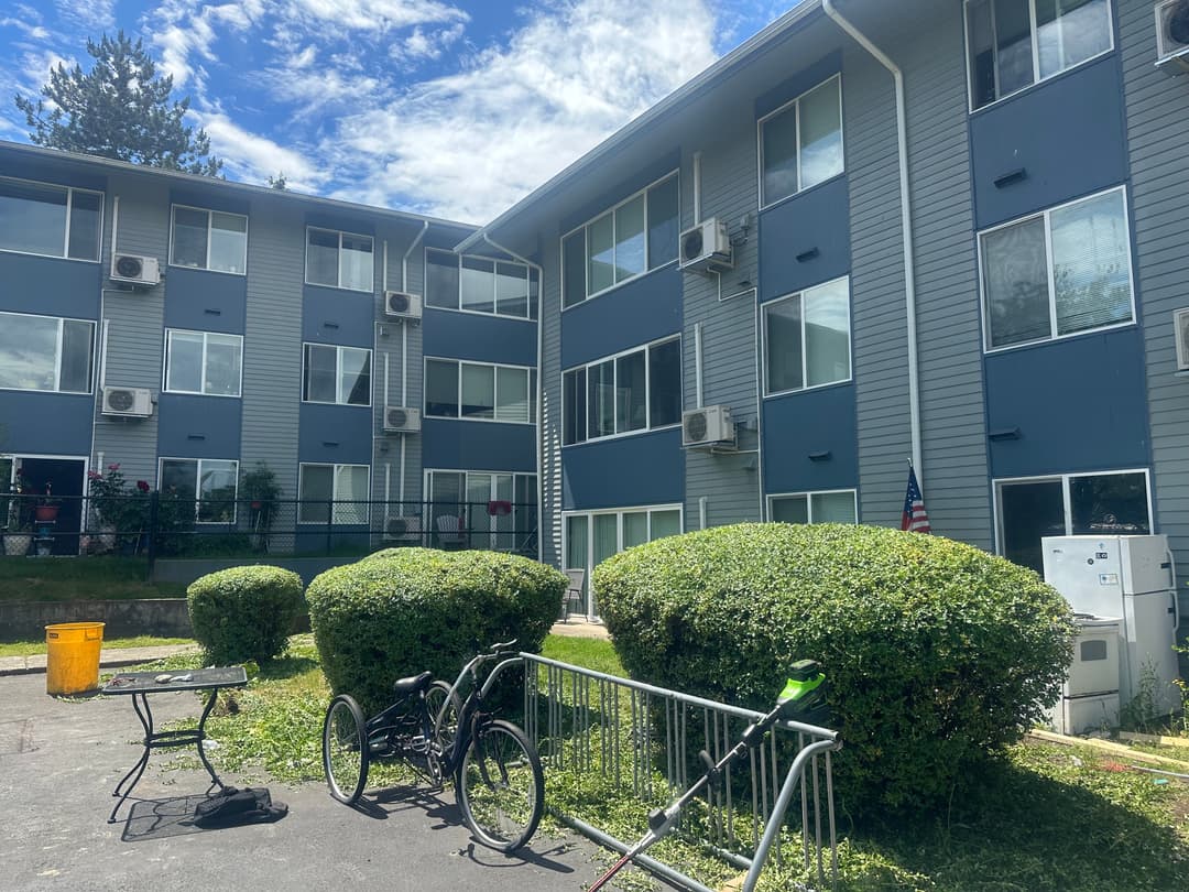 picture of beautifully landscaped commercial apartment building with pruned bushes and cut lawn