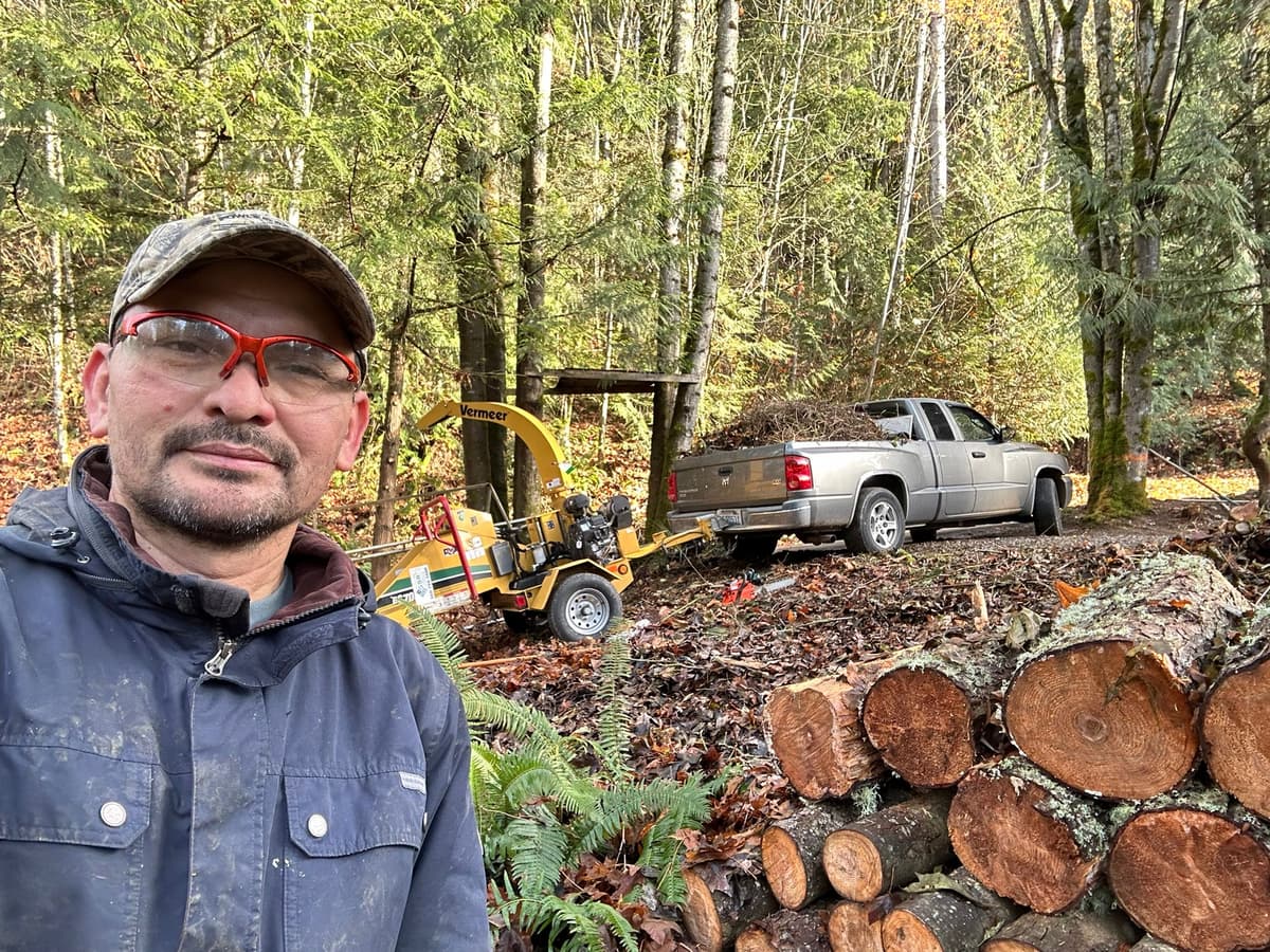 Picture of aJulio the owner of 503Landscape in front of his truck and his tree care equipment
